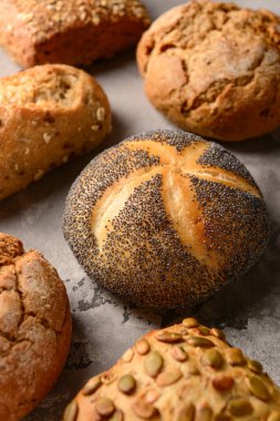 Gri grunge arka planında farklı taze çörekler.