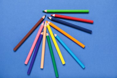 Mavi arkaplanda renkli kalemler kümesi