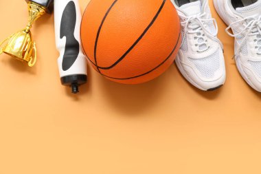 Basketbol, beyaz spor ayakkabıları, turuncu arka planda bardak ve spor şişesi.