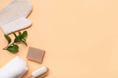 Masaj eldiveni, sabun çubuğu ve bej arka planda havlusu olan güzel bir kompozisyon