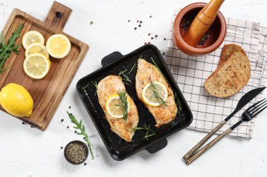 Hafif arka planda kızarmış tavuk göğsü, baharatlar ve limonlu kompozisyon