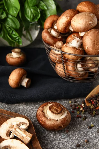 Fesleğenli taze mantar sepeti ve gri arka planda biber.