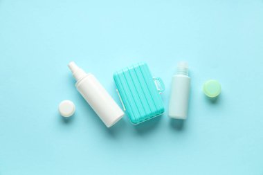 Renkli arka planda seyahat kozmetik seti ve mini bavul kompozisyonu