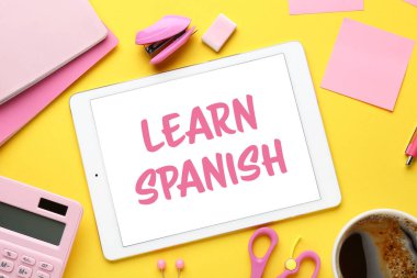 Sarı arkaplanda LEARN SPANISH yazılı farklı okul sayfası ve tablet bilgisayarı