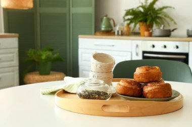 Modern mutfakta tarçınlı, çay yapraklı ve fincanlı yemek masası.