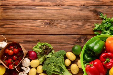 Domatesli kağıt torba, taze sebzeler ve ahşap arka planda mantarlar.