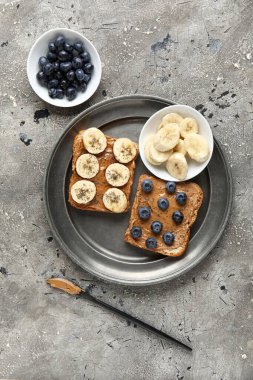 Fıstık ezmeli, yaban mersinli ve muzlu tost tabağı.
