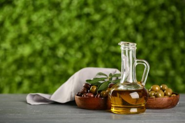 Açık havada gri ahşap masada taze zeytinyağı.