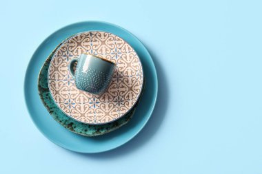 Tabak, kase, tabak ve fincan mavi arka planda. Üst görünüm