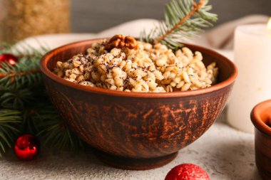 Beyaz masa üzerinde köknar dalları ve Noel topları olan geleneksel Ukrayna Kutya tabağı.