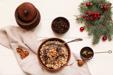 Köknar dalları ve beyaz ahşap arka planda Noel topları olan geleneksel Ukrayna Kutya tabağı