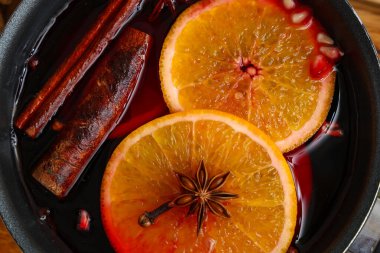 Turuncu, nar ve farklı baharatlı sıcak şarap tenceresi, yakın plan.