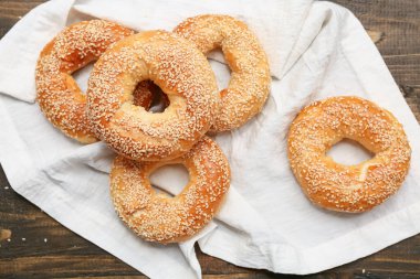 Tahta arka planda susam tohumlu lezzetli simitler.