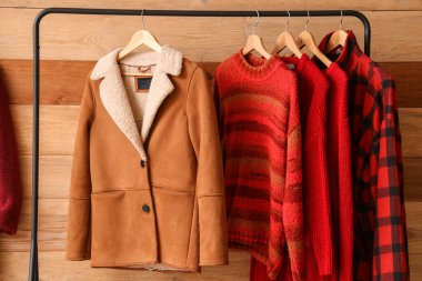 Kışlık giysilerle ahşap duvarın yanına dizilin.