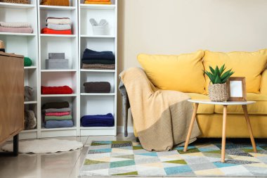 İçinde kanepe, raf ve kışlık giysiler olan soyunma odası.