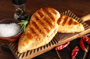 Lezzetli ızgara tavuk göğsü, biberiye, tuz, biber ve ahşap arka planda kurutulmuş kırmızı biber.