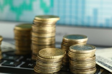 Grafikli bilgisayar ekranının yanında altın sikkeler ve para