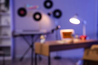 İş yeri, sentezleyici ve vinil disklerle karanlık podcaster stüdyosunun bulanık görüntüsü