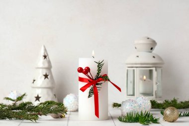 Beyaz fayans masasında yanan mum ve Noel süsü