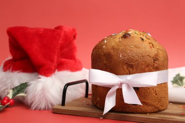 Kırmızı arka planda Noel Baba şapkası olan Panettone