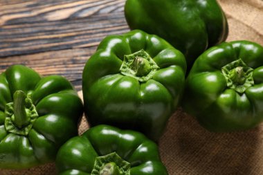 Ahşap arka planda yeşil dolmalık biberler, yakın plan