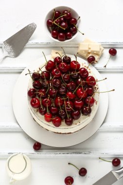 Beyaz ahşap arka planda vişneli pasta.
