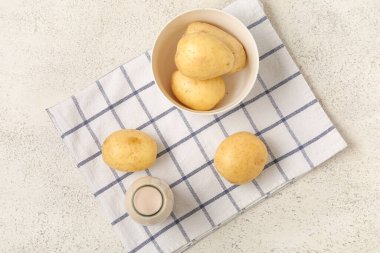 Bir şişe lezzetli patates sütü ve hafif arka planda taze sebzeler.