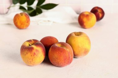 Tatlı şeftali ve yapraklar beyaz masada