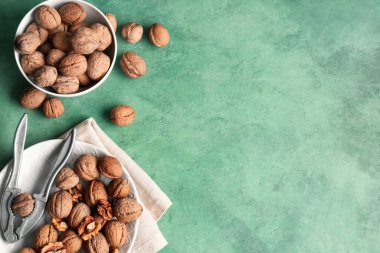 Yeşil arka planda lezzetli cevizli tabak ve kase.