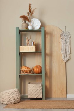 İçinde raf ünitesi, puf ve balkabağı olan bir oda.