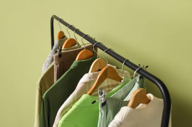 Yeşil duvarın yanında şık kıyafetler var. Yakın çekim.