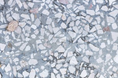 Arka planda ezilmiş taşlar olan beton dokusu, yakın plan.
