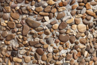 Arka planda çakıl taşları olan betonun dokusu, yakın plan