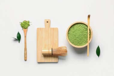 Pudralanmış kiraz çayı, chasen, kaşık, taze yapraklar ve bej arkaplanda chashaku ile kase.