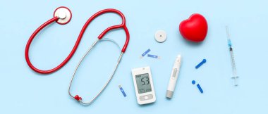 Mavi arka planda neşter, şerit ve steteskoplu glukometre. Diyabet kavramı