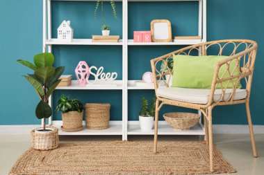 Koltuk ve raf ünitesi. Kitaplar mavi duvarın yanında.