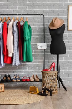 Manken, ayakkabı ve elbise askısı olan soyunma odasının içinde.