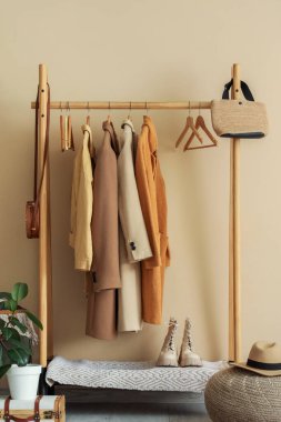 Odada bej duvarın yanında palto ve çantalarla dizilin.