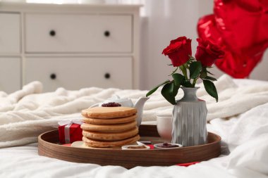 Kahvaltı tepsisi, güller ve sevgililer günü hediyesi odada, kapalı.
