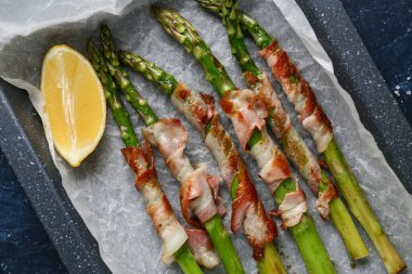 Pastırmalı ve limonlu fırında yeşil kuşkonmaz, yakın plan.