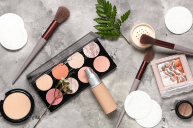 Pamuk yastıklı kompozisyon, gri grunge arka planda yeşil dal ve makyaj ürünleri, yakın plan