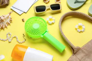 Yaz aksesuarları ve sarı arka planda mini yelpaze.