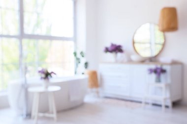 Lavabo, küvet ve vazolarda leylak çiçekleri olan bulanık banyo manzarası.