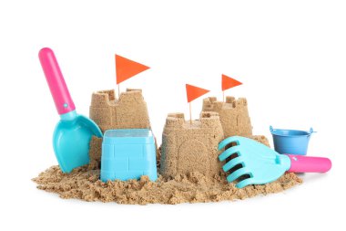 Beyaz arka planda kumdan ve plaj oyuncaklarından yapılmış bir kale.