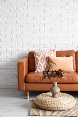 Oturma odasının içinde kahverengi kanepe ve puf.