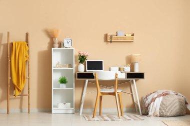 Modern dizüstü bilgisayarı ve güzel çiçekleri olan şık bir çalışma alanı.