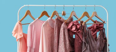 Mavi arka planda şık elbiselerle dizilin