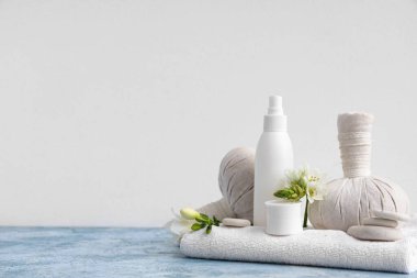 Kozmetik ürünleri, spa aksesuarları ve çiçeklerle renk tablosunda ışık arka planına karşı kompozisyon