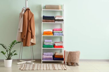 Soyunma odasının içinde giysi olan askı ve raflar.