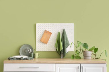 Mutfaktaki yeşil duvarın yanında asılı temiz havlular.